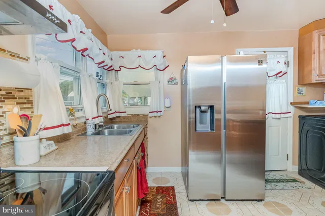 a kitchen with stainless steel appliances granite countertop a refrigerator a oven and a sink