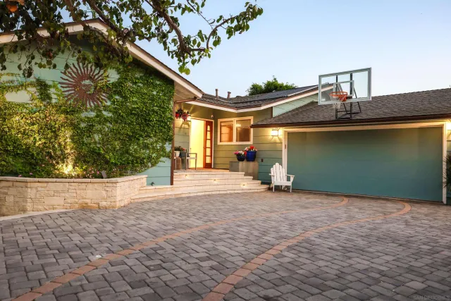 a front view of a house with a yard and potted plants