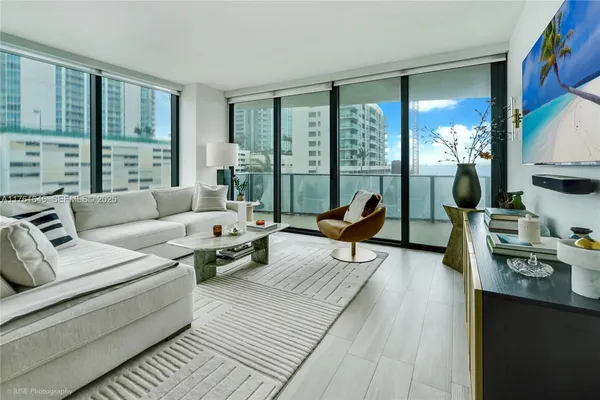 a living room with furniture and large windows