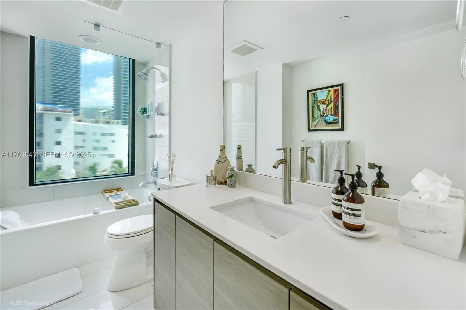 Edgewater Miami, FL 33137 - Photo 7 of 15 a bathroom with a sink a toilet and a large mirror