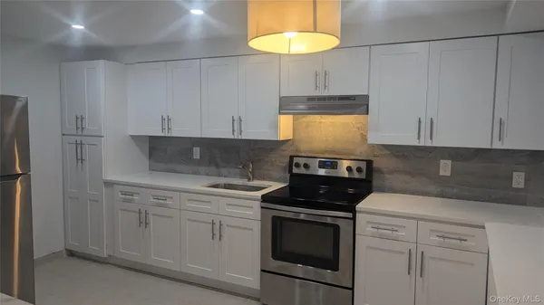 a kitchen with white cabinets and white appliances