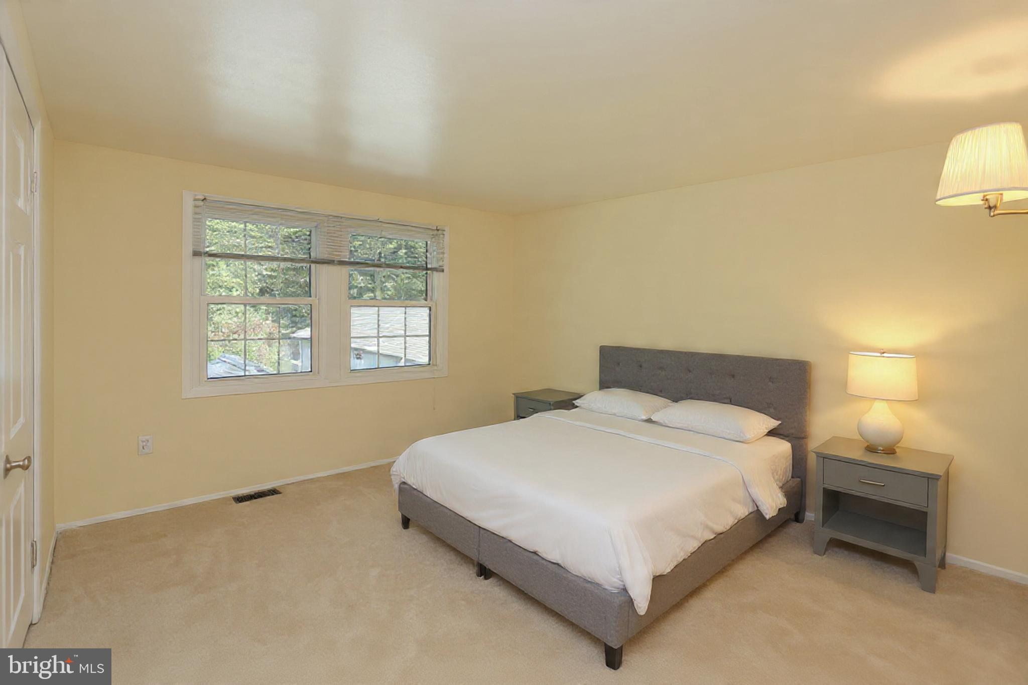 9110 Montpelier Drive Laurel, MD 20708 - Photo 20 of 30 a bedroom with a bed lamp and a window