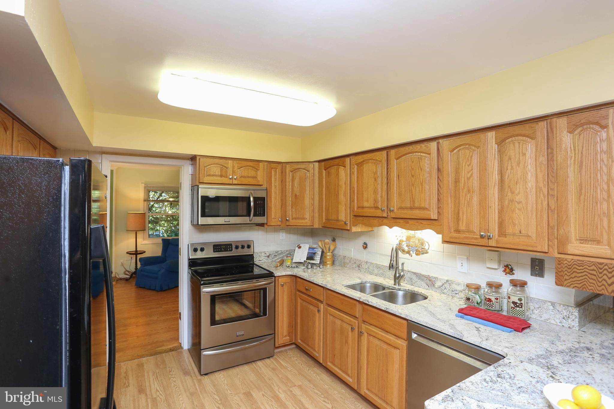 9110 Montpelier Drive Laurel, MD 20708 - Photo 9 of 30 a kitchen with granite countertop stainless steel appliances and wooden cabinets