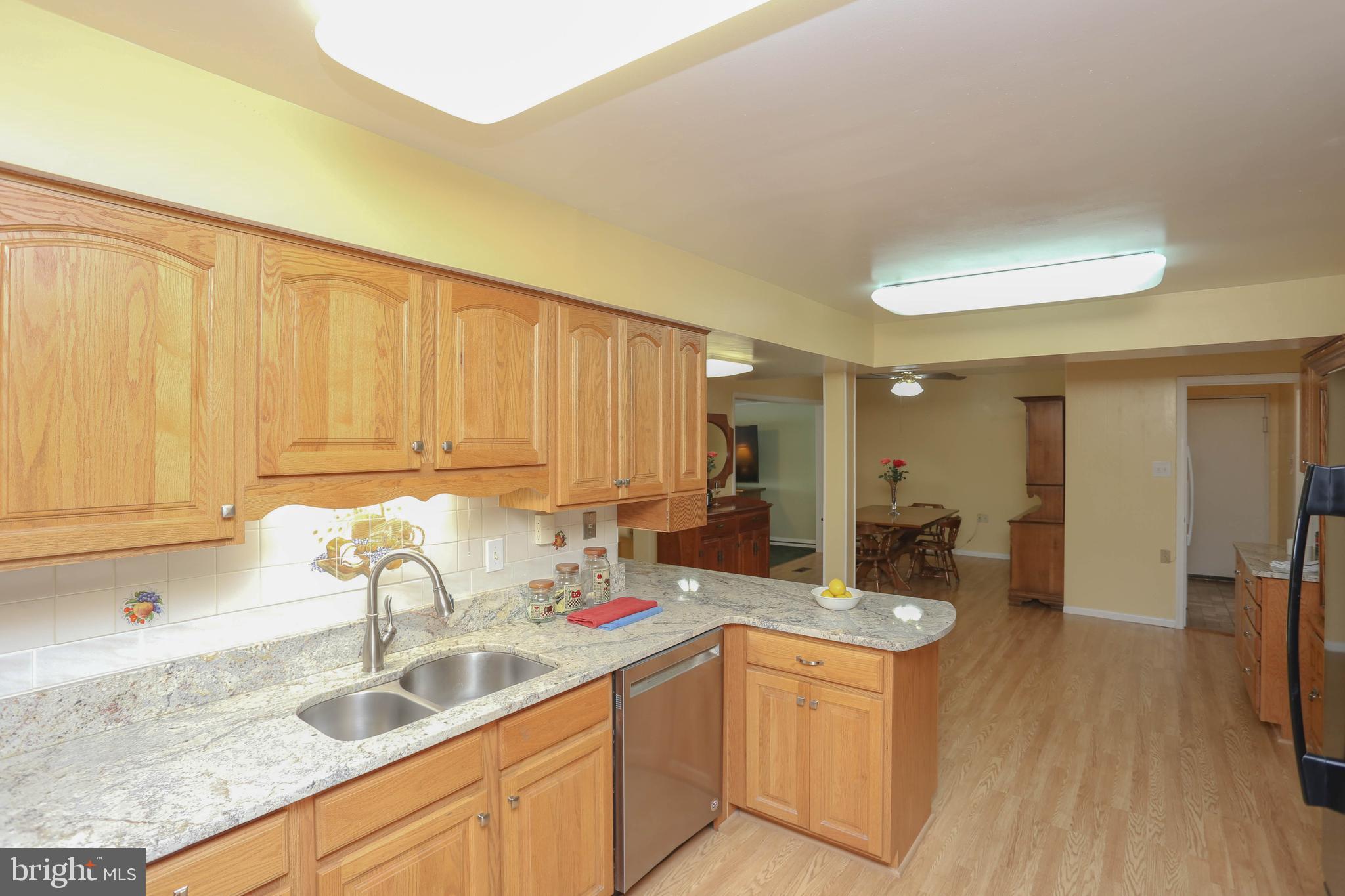 9110 Montpelier Drive Laurel, MD 20708 - Photo 10 of 30 a kitchen with stainless steel appliances granite countertop a sink a stove and a wooden floors
