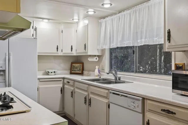 a kitchen with a sink a stove and cabinets