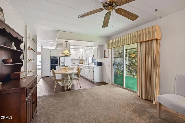 a living room with furniture a ceiling fan and a window