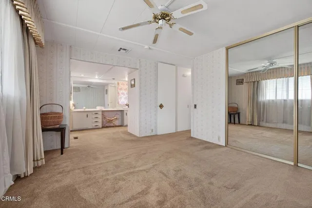 an empty room with closet and windows