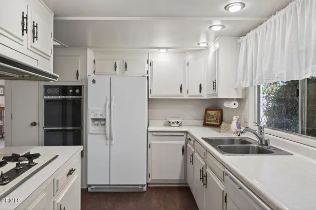 a kitchen with white cabinets and appliances