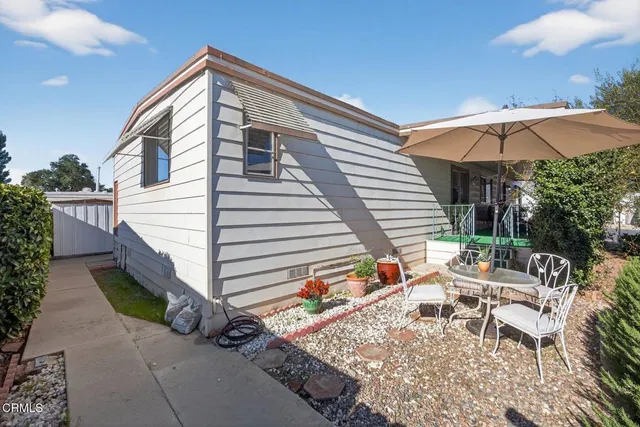 a view of house with backyard and sitting area