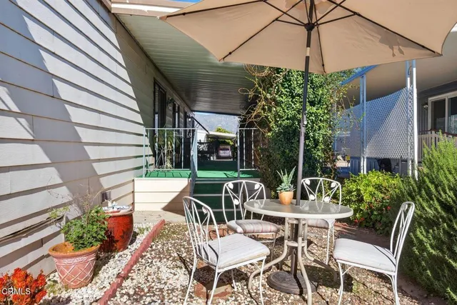 a view of a patio with a table and chairs under an umbrella