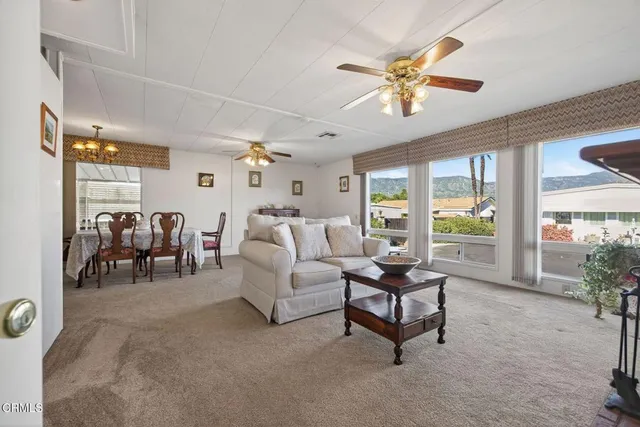 a living room with furniture and three windows