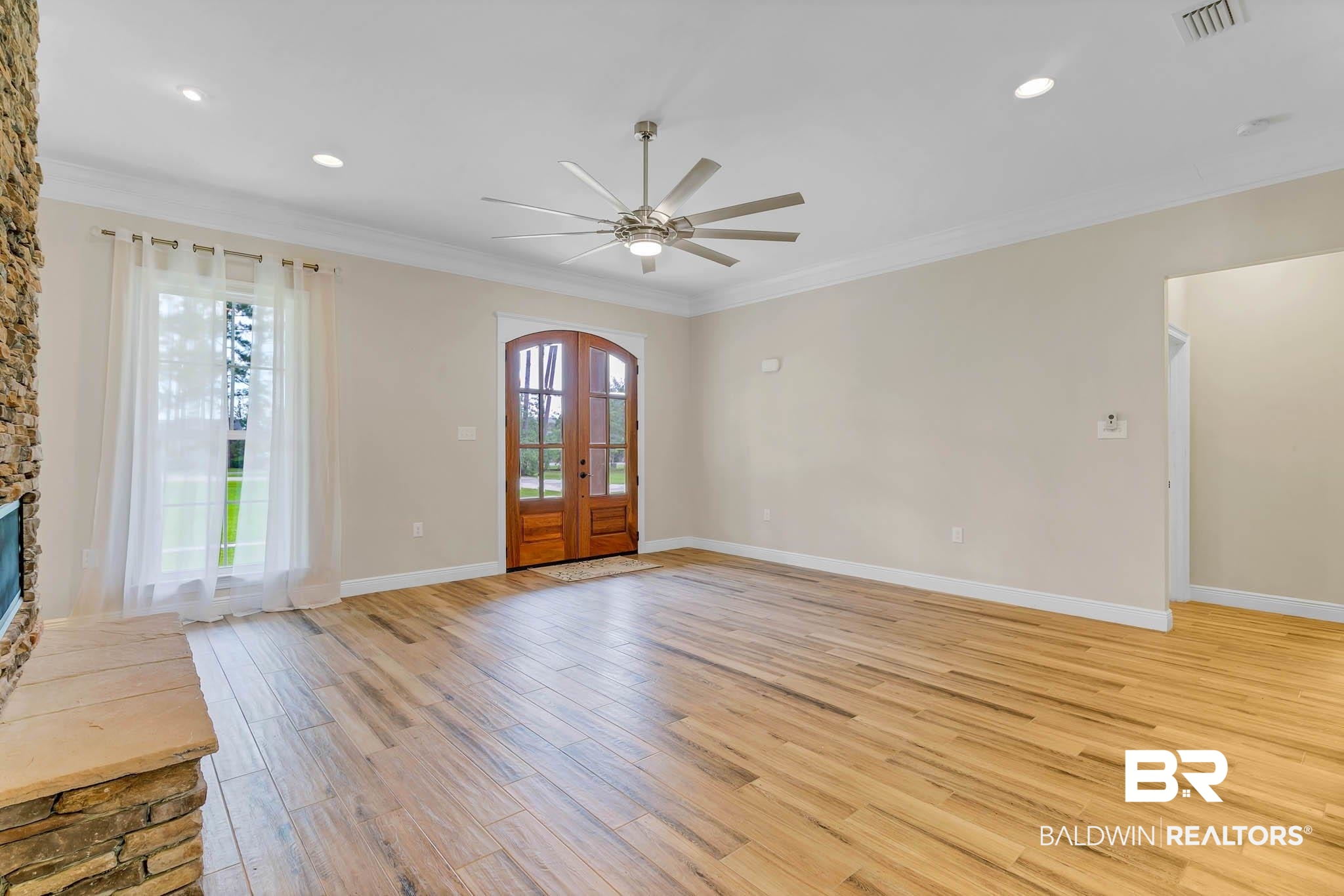 8145 Bay View Drive Foley, AL 36535 - Photo 10 of 81 Unfurnished living room with ornamental molding, light wood finished floors, ceiling fan, recessed lighting, and french doors