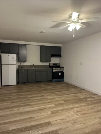 a view of an empty room with window and chandelier fan