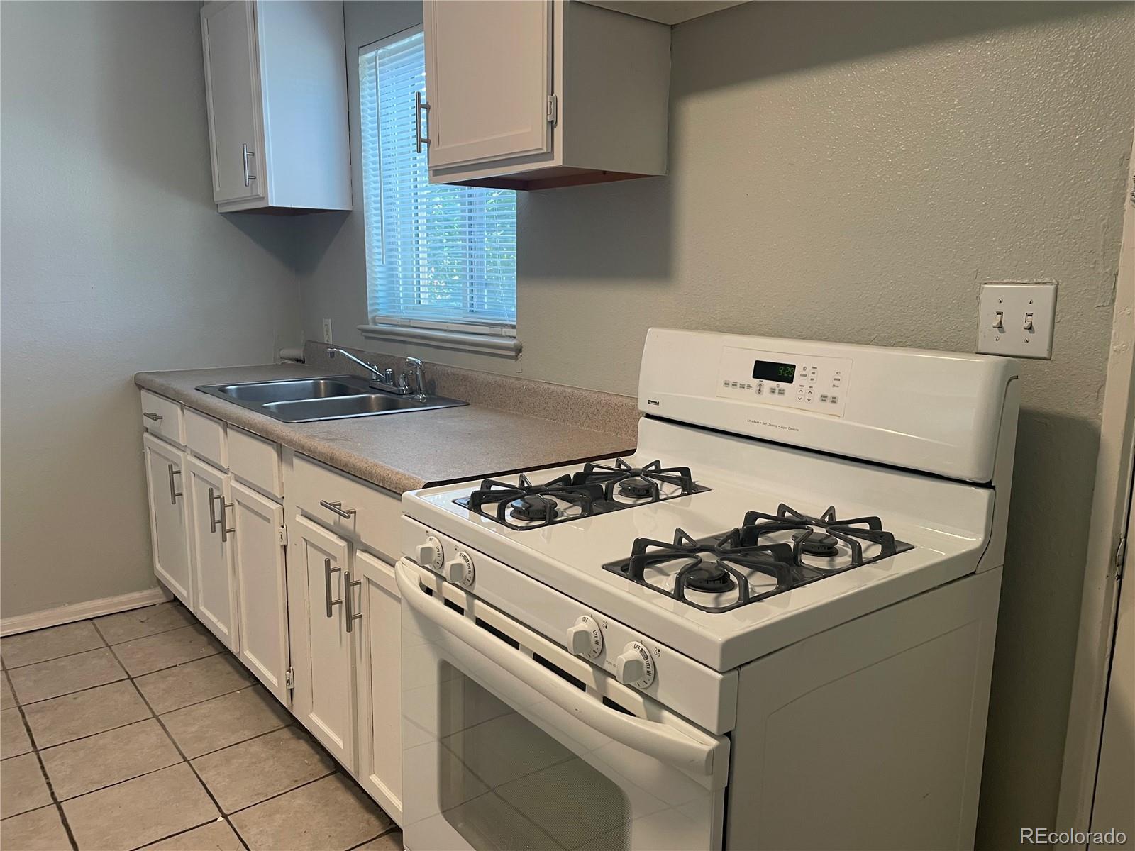 1528 Ulster Street Denver, CO 80220 - Photo 5 of 8 a white stove top oven sitting inside of a kitchen