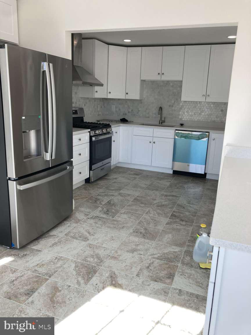 806 Rhodes Avenue Jenkintown, PA 19046 - Photo 8 of 16 a kitchen with stainless steel appliances granite countertop a refrigerator a stove and a sink