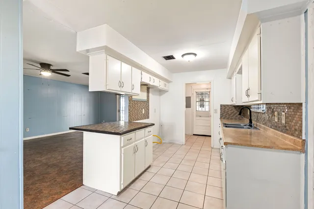 a kitchen with granite countertop a stove top oven and cabinets