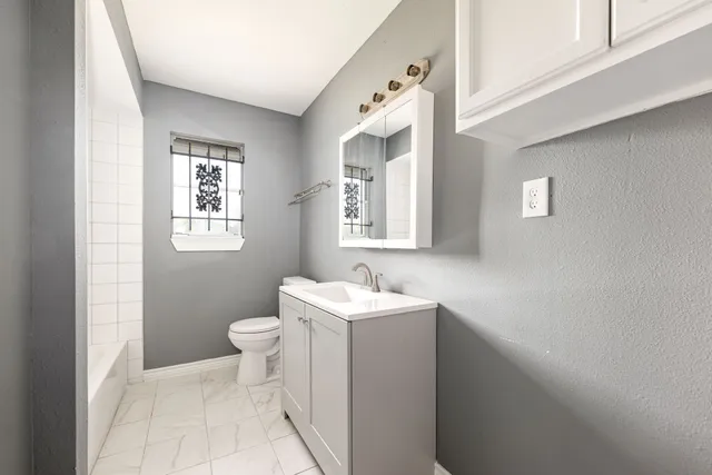 a view of an empty room with closet and a window