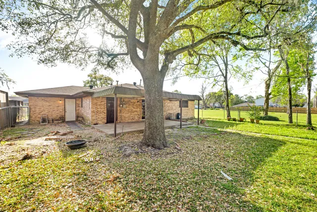 a view of a house with backyard and a tree