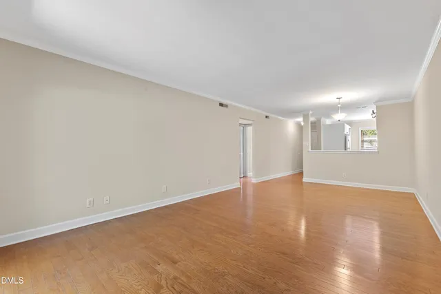 a view of an empty room with wooden floor