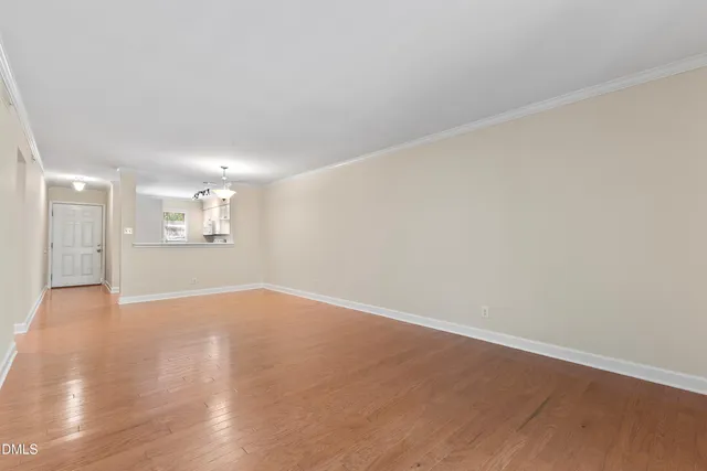 a view of an empty room with wooden floor