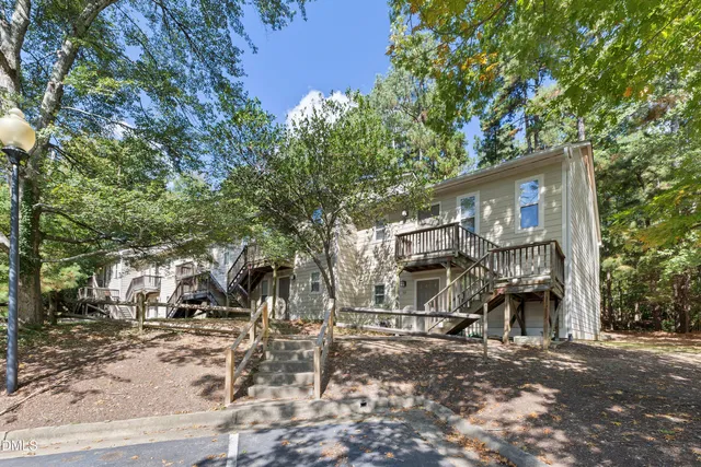 a front view of a house with a tree
