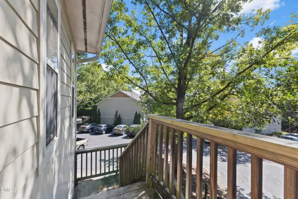 a view of a balcony with floor to ceiling window and wooden fence