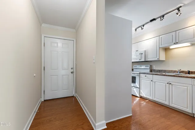 a kitchen with granite countertop white cabinets and white appliances