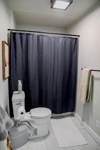 a white toilet sitting next to a bathroom