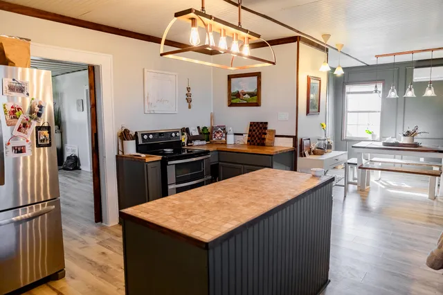 a kitchen with a stove a refrigerator and a dining table