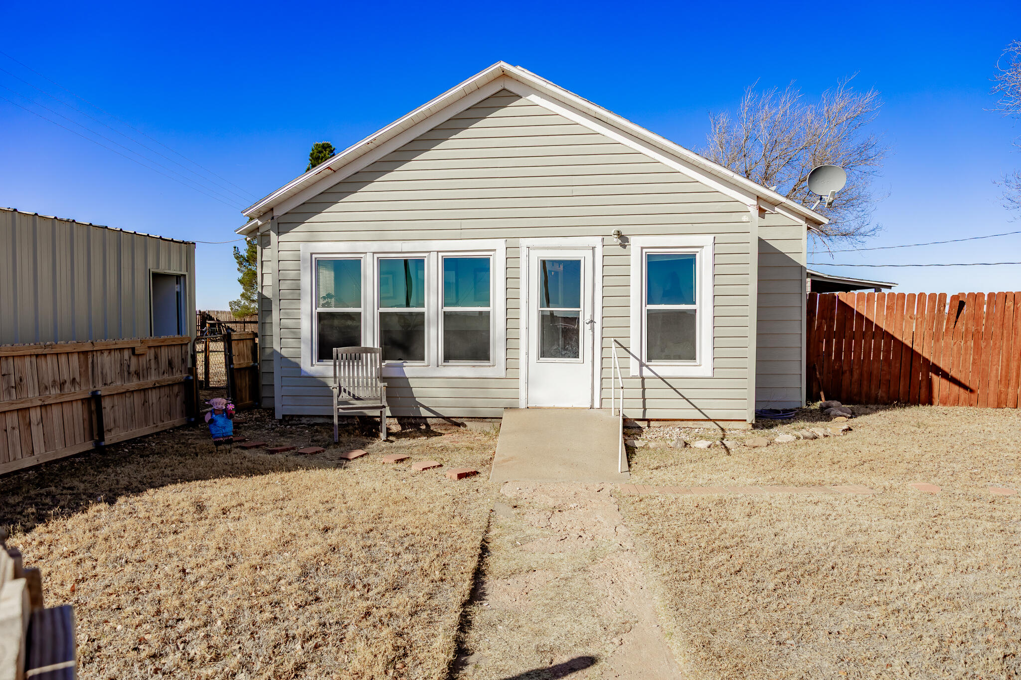 1398 County Road 155 Post, TX 79356 - Photo 2 of 26 a backyard of a house with barbeque oven table and chairs
