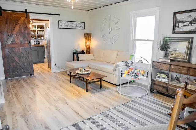 a living room with furniture and a wooden floor