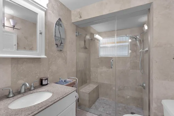 a bathroom with a sink toilet a mirror and shower