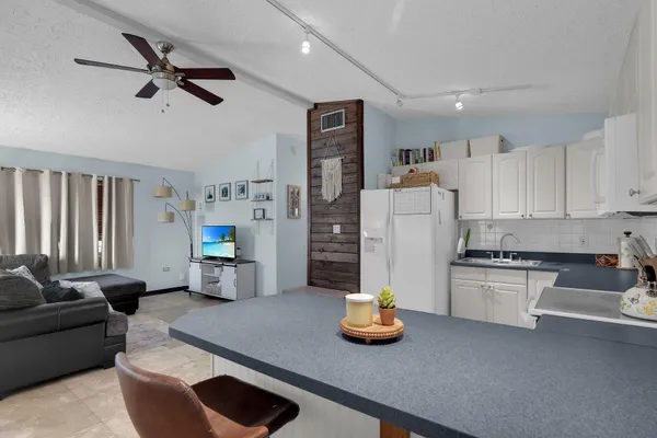 a living room with furniture and kitchen