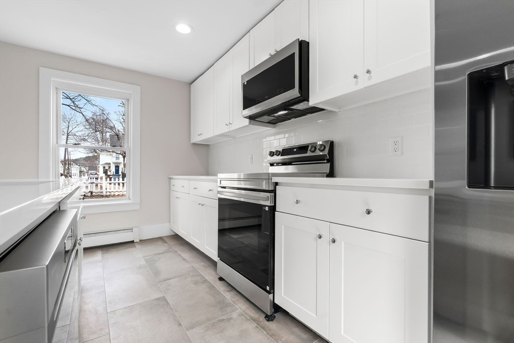 2 Perkins Street Amesbury, MA 01913 - Photo 3 of 36 a kitchen with stainless steel appliances a stove microwave and white cabinets