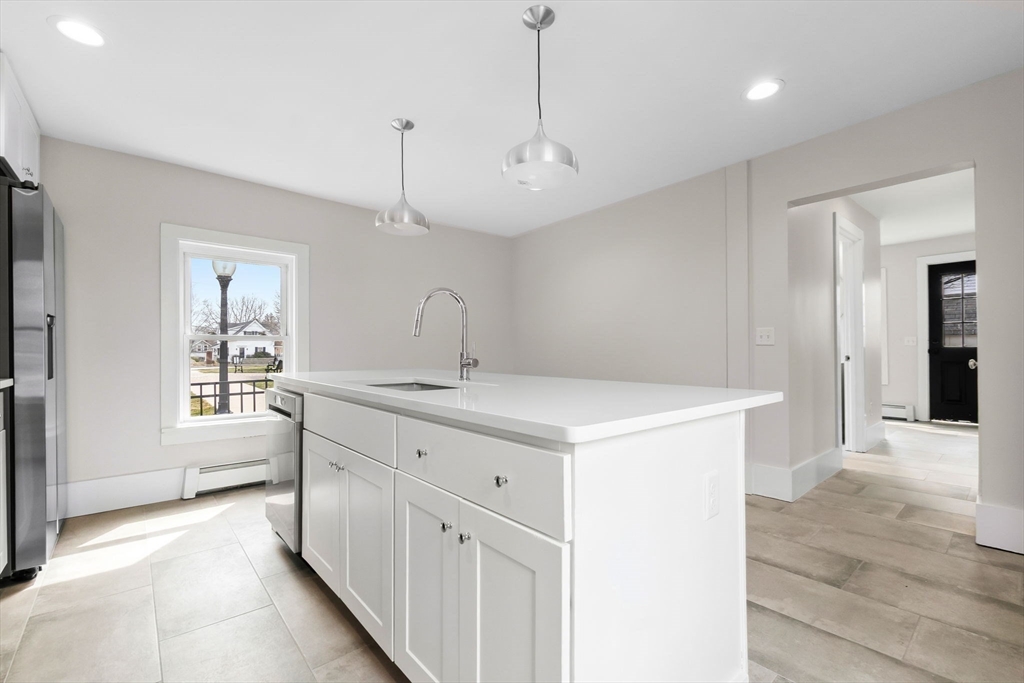 2 Perkins Street Amesbury, MA 01913 - Photo 5 of 36 a large white kitchen with a sink a refrigerator and window
