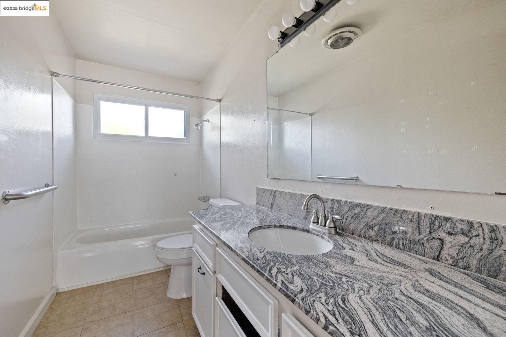 10562 Suzanne Court Jamestown, CA 95327 - Photo 10 of 14 a bathroom with a granite countertop sink a toilet and bathtub