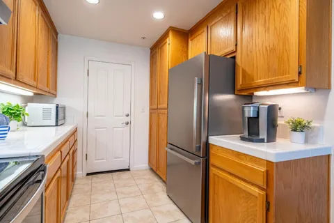 a kitchen with stainless steel appliances granite countertop a refrigerator a sink and dishwasher