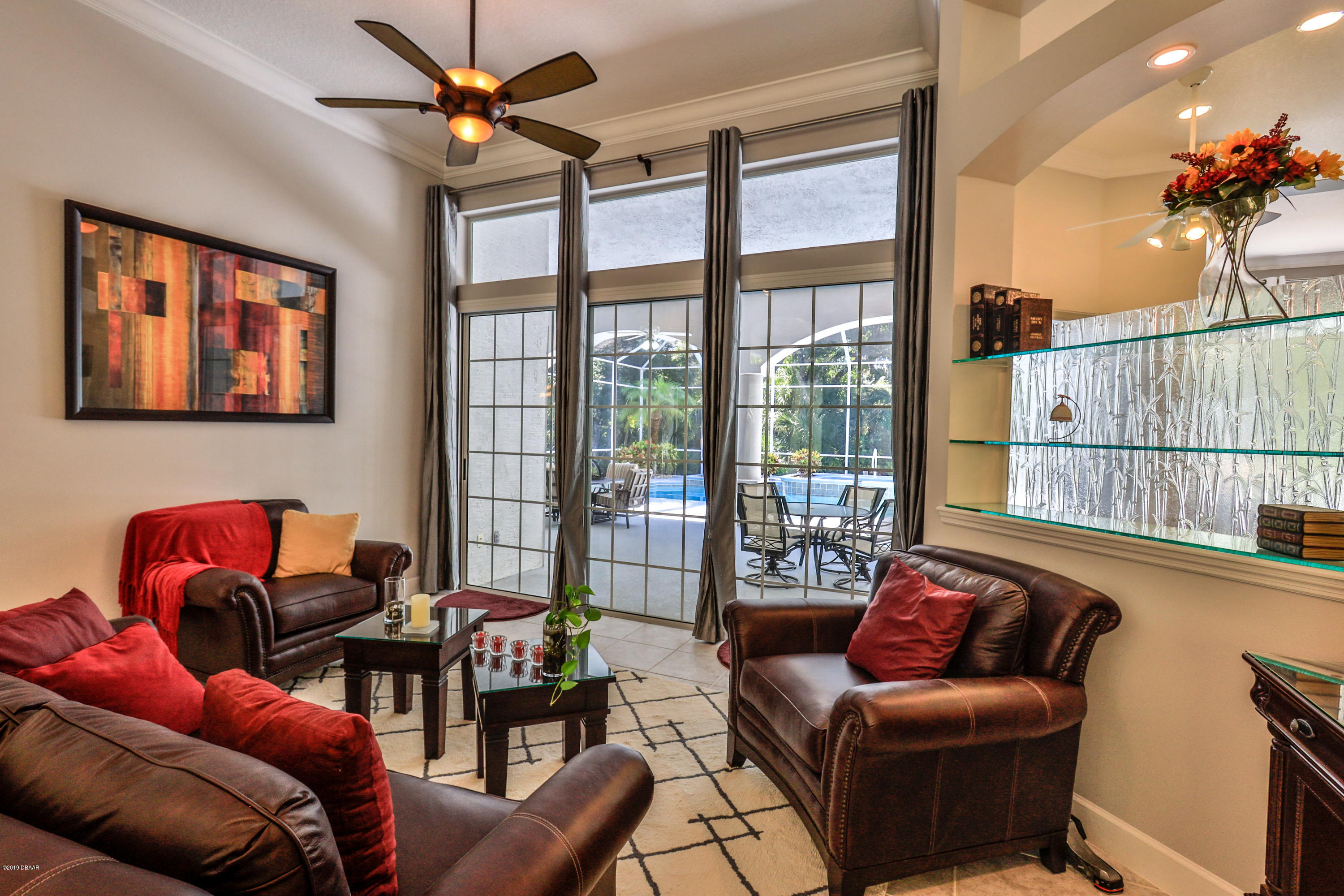 117 Beach Street Ponce Inlet, FL 32127 - Photo 11 of 37 a living room with furniture a chandelier and a floor to ceiling window