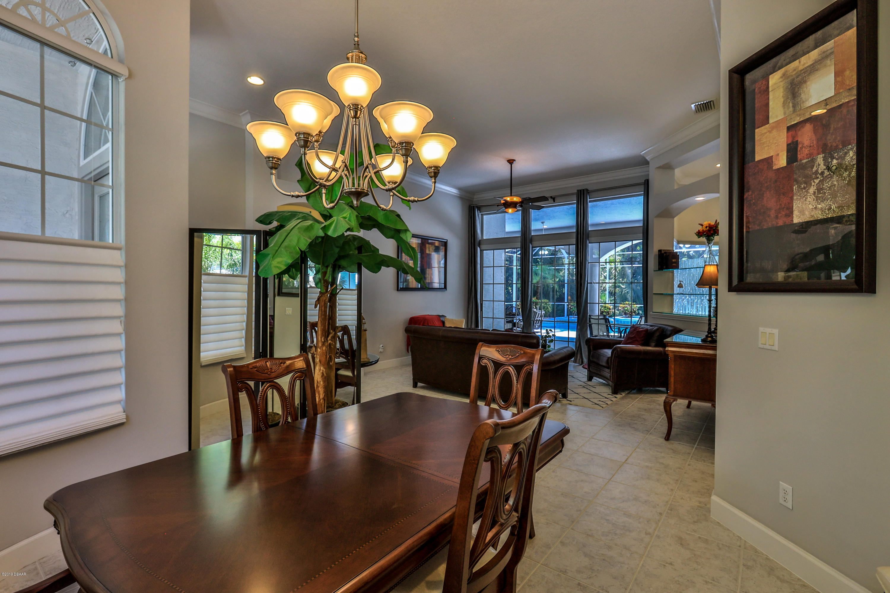 117 Beach Street Ponce Inlet, FL 32127 - Photo 12 of 37 a dining room with wooden floor a chandelier a wooden table and chairs