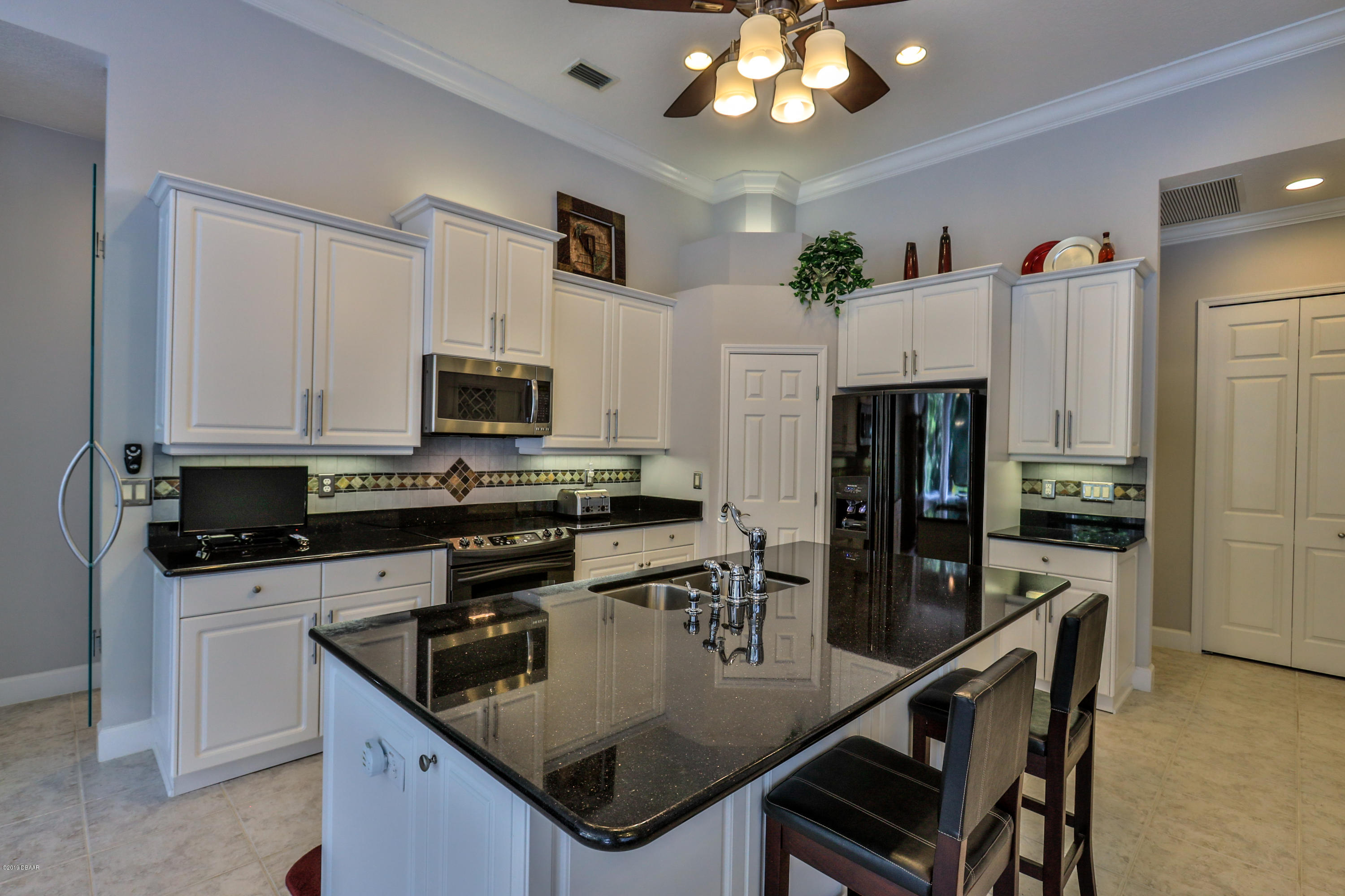 117 Beach Street Ponce Inlet, FL 32127 - Photo 16 of 37 a kitchen with stainless steel appliances granite countertop a sink a stove and a refrigerator