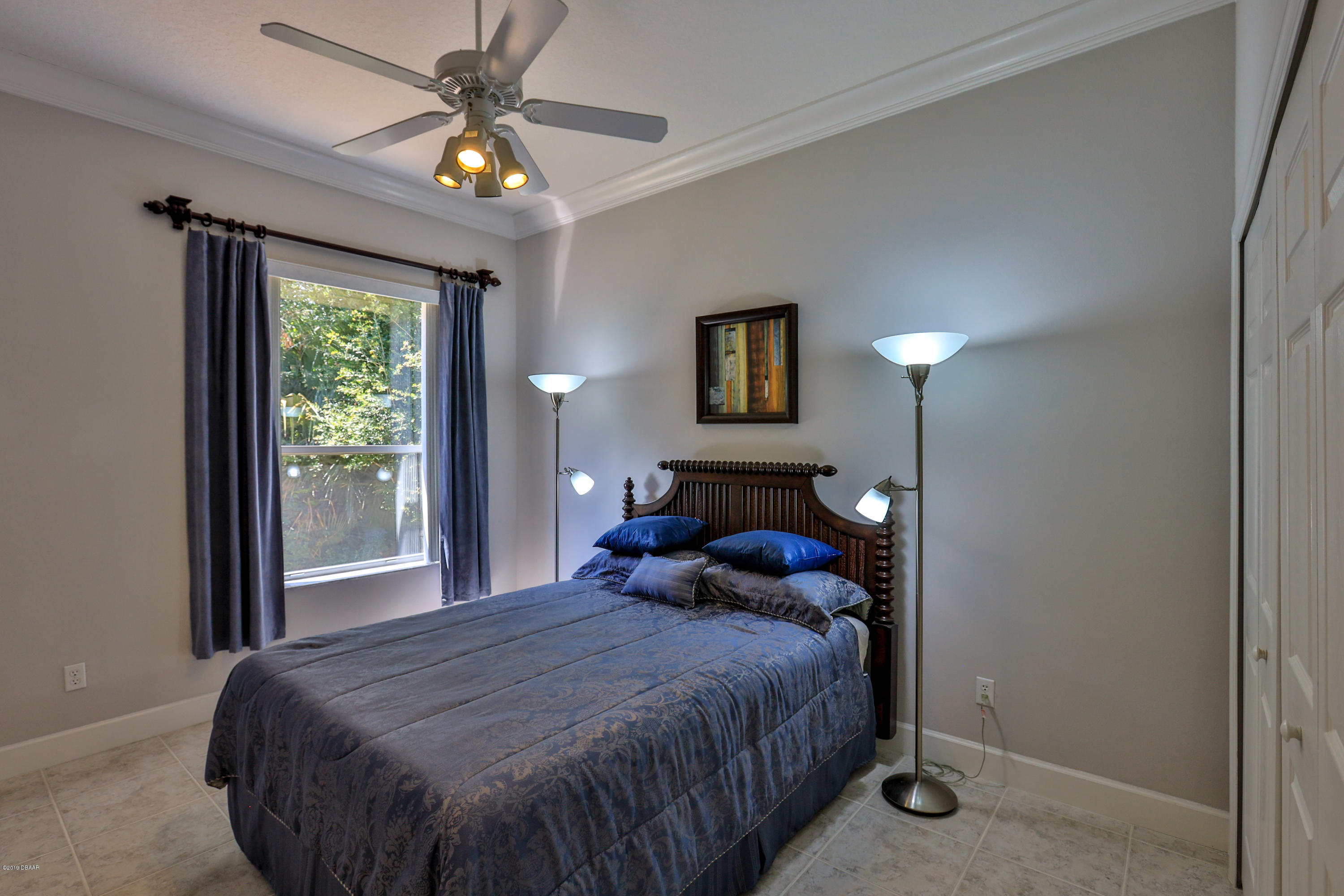 117 Beach Street Ponce Inlet, FL 32127 - Photo 23 of 37 a bedroom with a bed and a chandelier