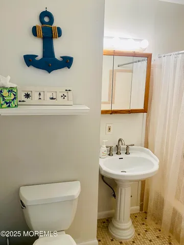 a bathroom with a sink a toilet and mirror