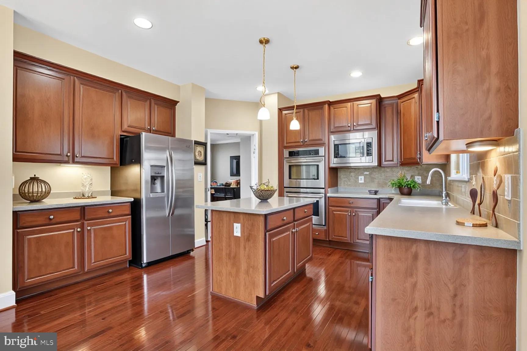 3308 McCorkle Court Triangle, VA 22172 - Photo 19 of 82 a kitchen with stainless steel appliances granite countertop a refrigerator a sink dishwasher a stove with wooden cabinets and floor