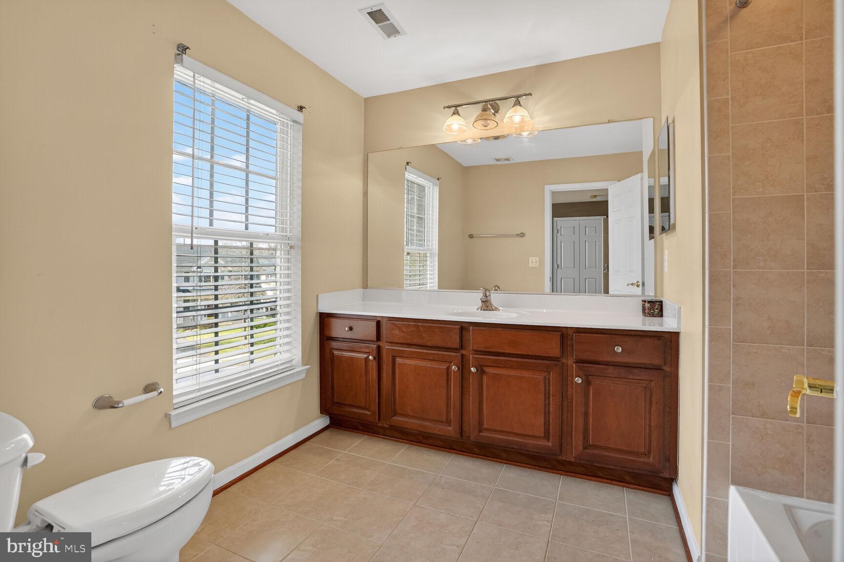3308 McCorkle Court Triangle, VA 22172 - Photo 46 of 82 a spacious bathroom with a granite countertop sink toilet a large mirror and a window