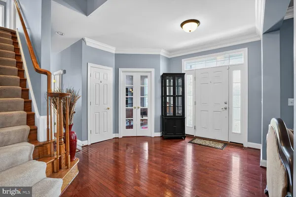 a kitchen with stainless steel appliances granite countertop a refrigerator a sink dishwasher a stove and a dining table with wooden floor