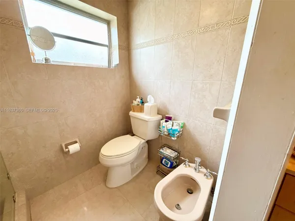 a white toilet sitting next to a white sink and vanity