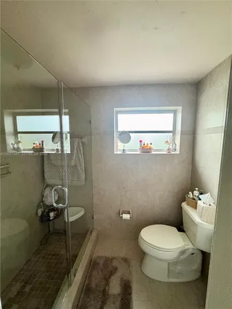 a white toilet sitting next to a bathroom sink