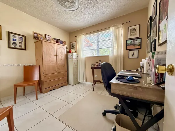 a view of a workspace with furniture and a window