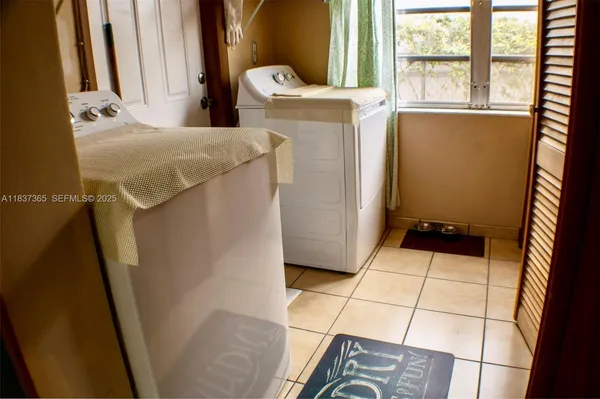 a room with washing machine and a shower