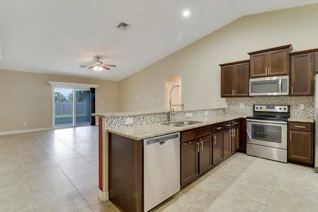 a kitchen with stainless steel appliances granite countertop a sink and cabinets